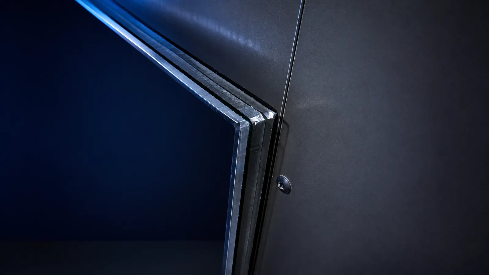 Close-up of an insulated glass unit corner showing the exposed warm-edge spacer between the sealed panes